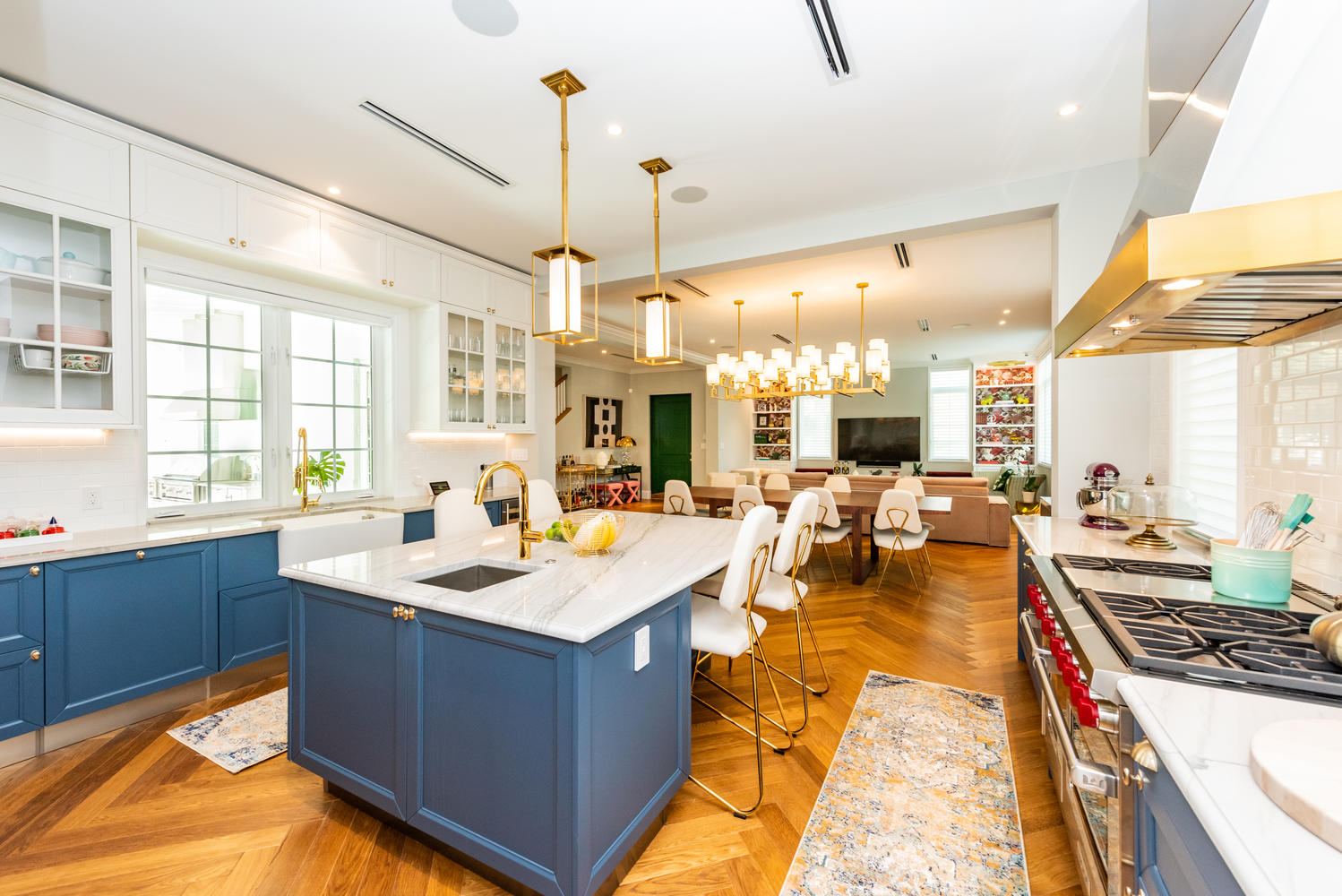Renovated kitchen with blue cabinetry and herringbone wood floor